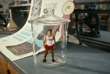 Animated gif from the movie Micro Mini Kids. A tiny guy in a lifeguard uniform is trapped in a glass specimen jar.